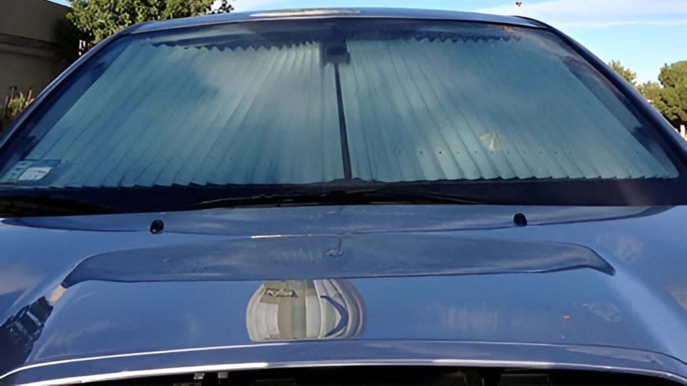 Car windshield sunshade secured with mounting clips for easy installation and secure fit.